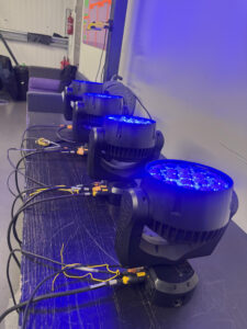 Moving head light undergoing DMX testing to verify colour, dimming, and rotation performance