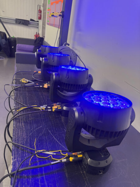 Moving head light undergoing DMX testing to verify colour, dimming, and rotation performance